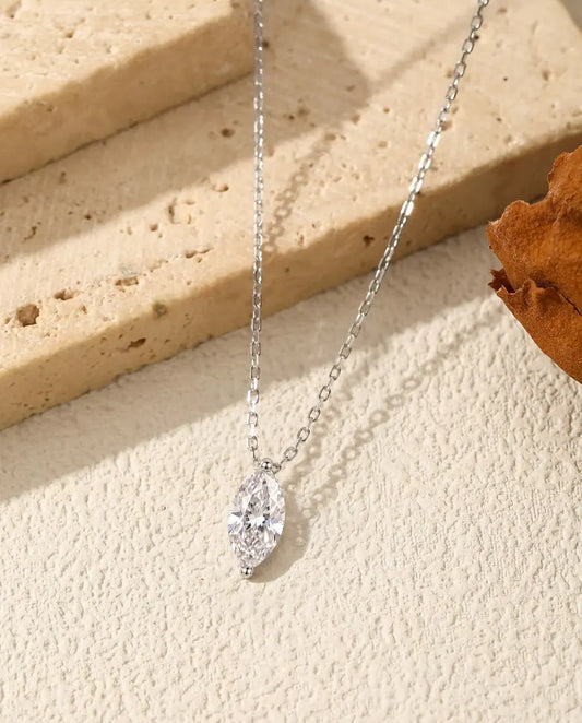 Collana Moissanite Marquise 1 ct in Argento 925 - ciondolo appeso al bordo di una lastra di travertino