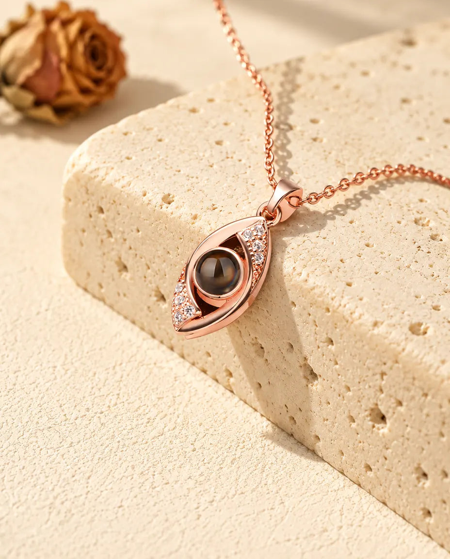 Collana a occhio greco color oro rosa con palpebre di zirconi attorno alla pietra della foto