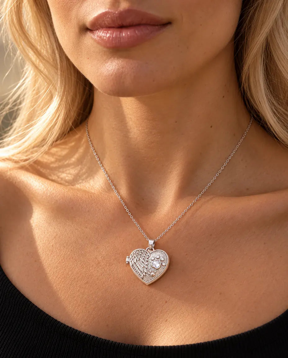Donna con un top nero in maglia che indossa la collana portafoto argentata a cuore con ala d'angelo e zampa