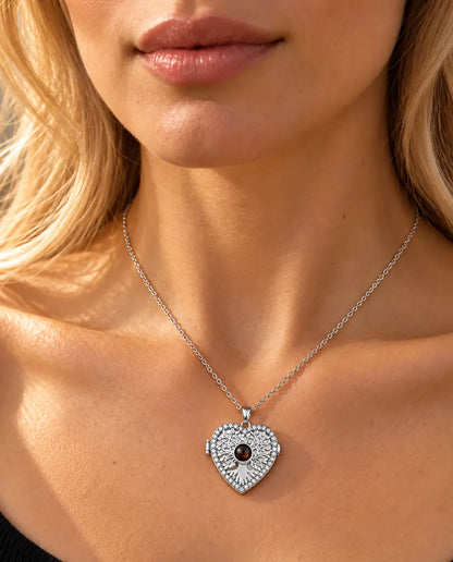 Donna con un top nero in maglia che indossa la collana portafoto argentata a cuore albero della vita