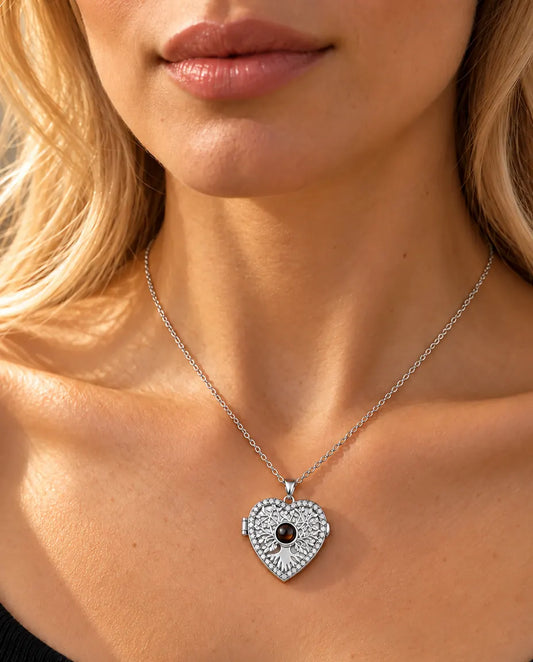 Donna con un top nero in maglia che indossa la collana portafoto argentata a cuore albero della vita
