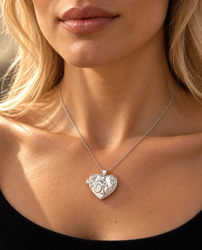 Donna con un top nero in maglia che indossa la collana portafoto argentata a cuore Donna e Cane