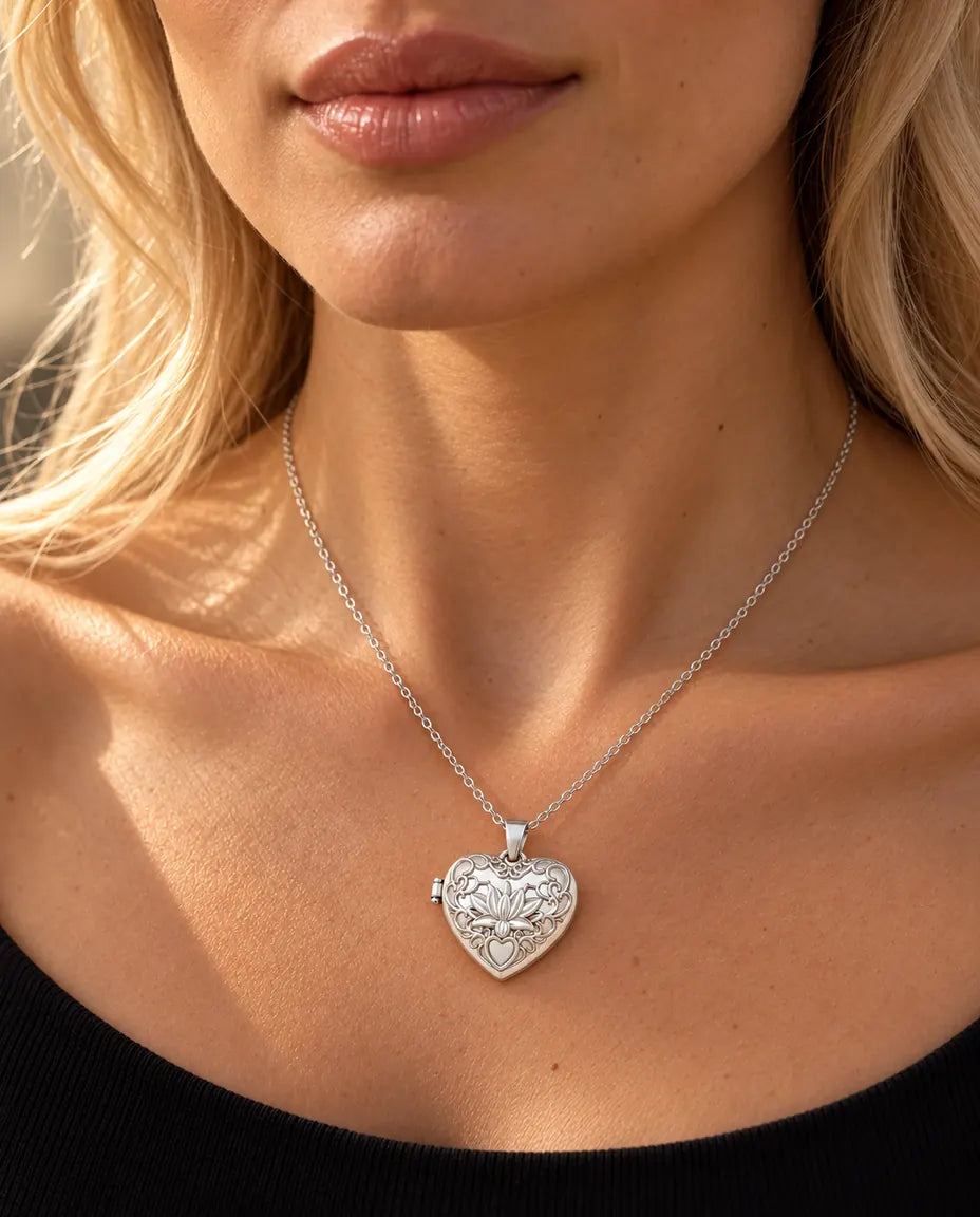 Donna con un top nero in maglia che indossa la collana portafoto argentata a cuore con fiore di loto