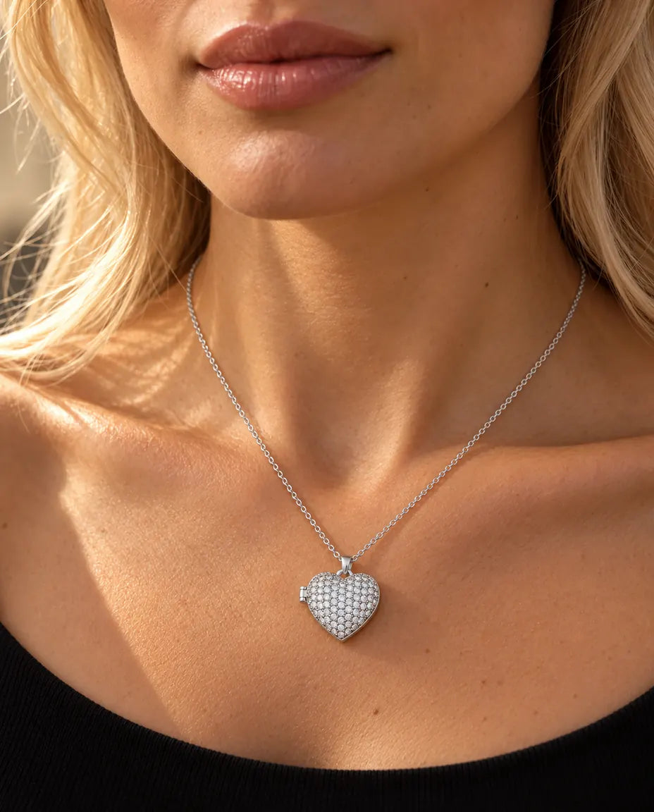 Donna con un top nero in maglia che indossa la collana portafoto a cuore pavé argentata