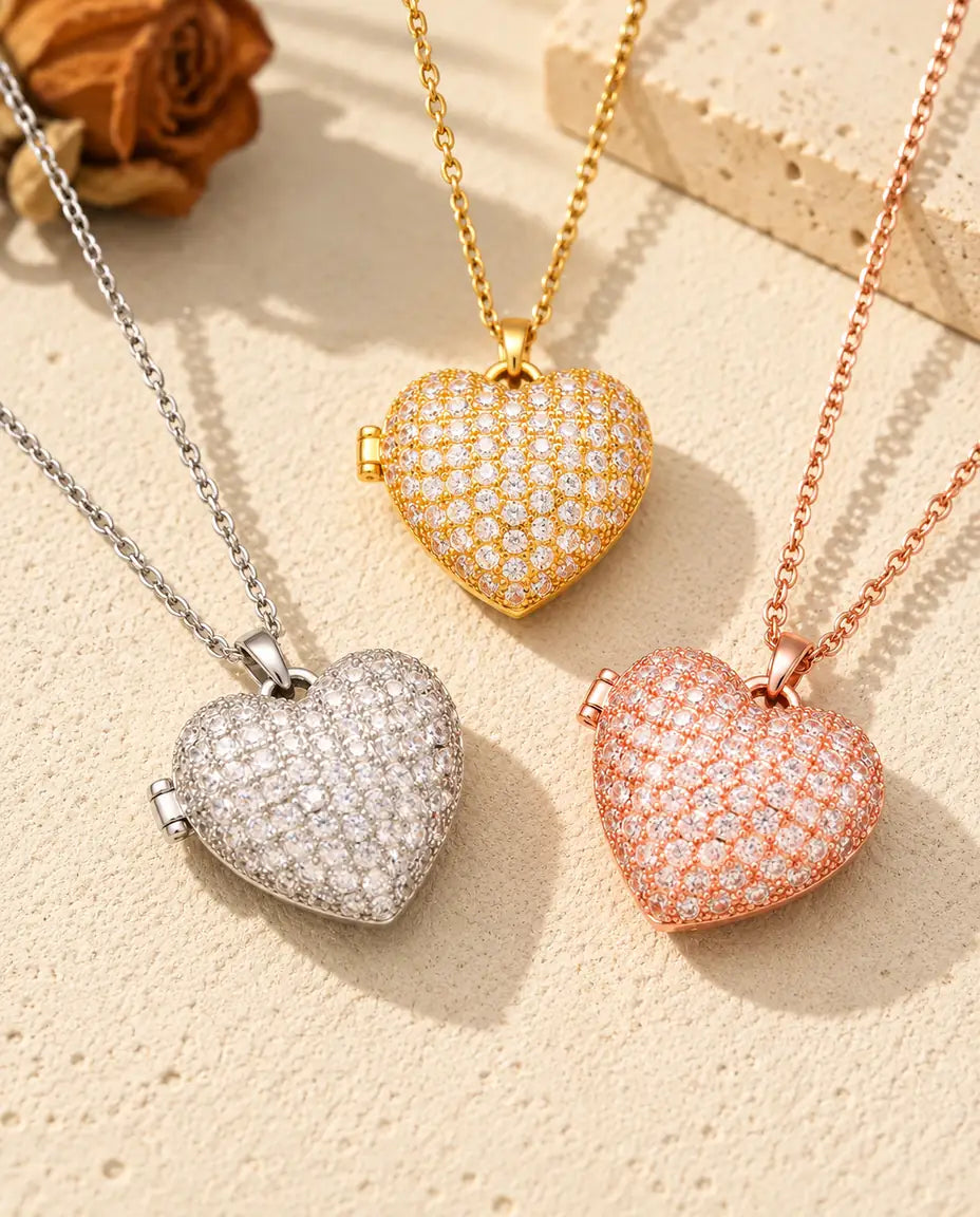 I tre colori della collana portafoto a cuore pavé disposti sul gesso