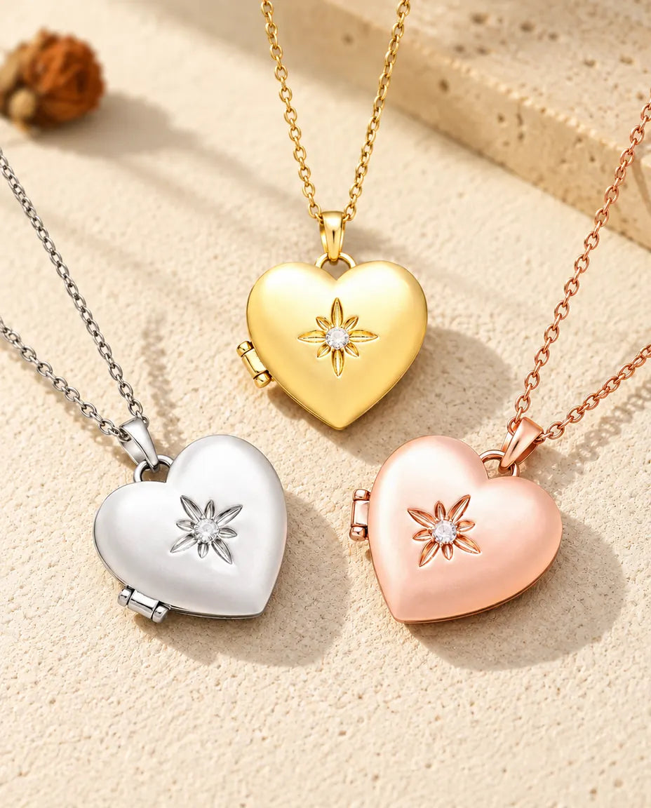 I tre colori della collana portafoto a cuore satinato con fiore disposti sul gesso