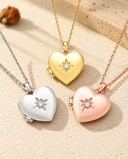 I tre colori della collana portafoto a cuore satinato con fiore disposti sul gesso