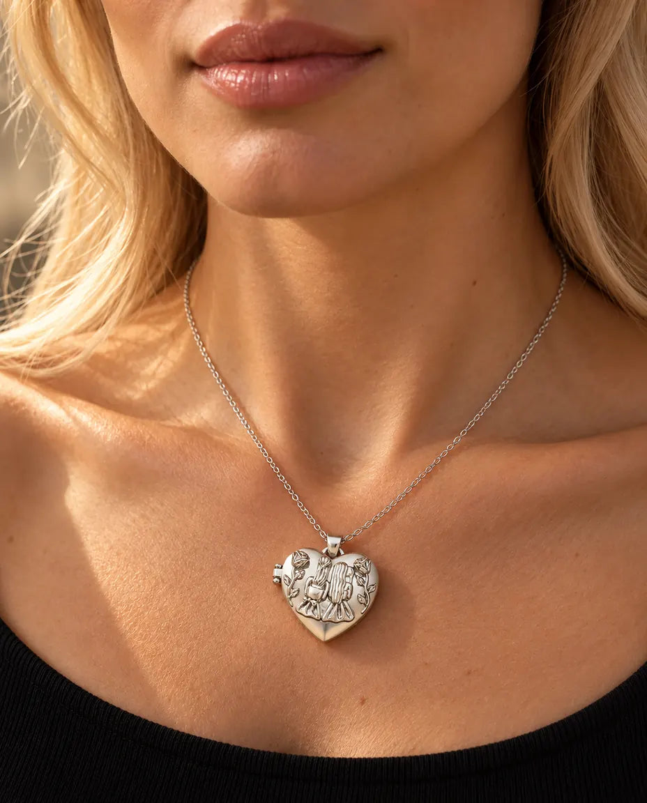 Donna con un top nero in maglia che indossa la collana portafoto argentata a cuore Sorelle