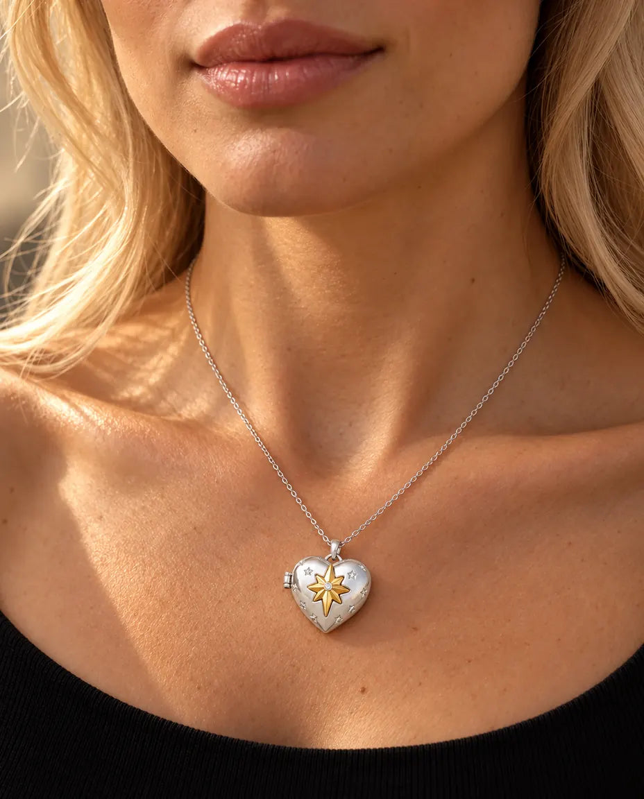 Donna con un top nero in maglia che indossa la collana portafoto a cuore con stella polare argentata