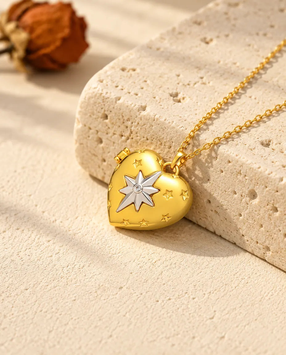 Collana portafoto a cuore con stella polare dorata appoggiata a un blocco di travertino