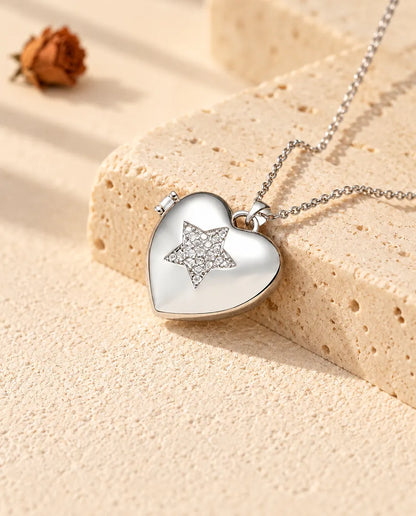 Collana portafoto a cuore con stella argentata con una stella di zirconi appoggiata a un blocco di travertino