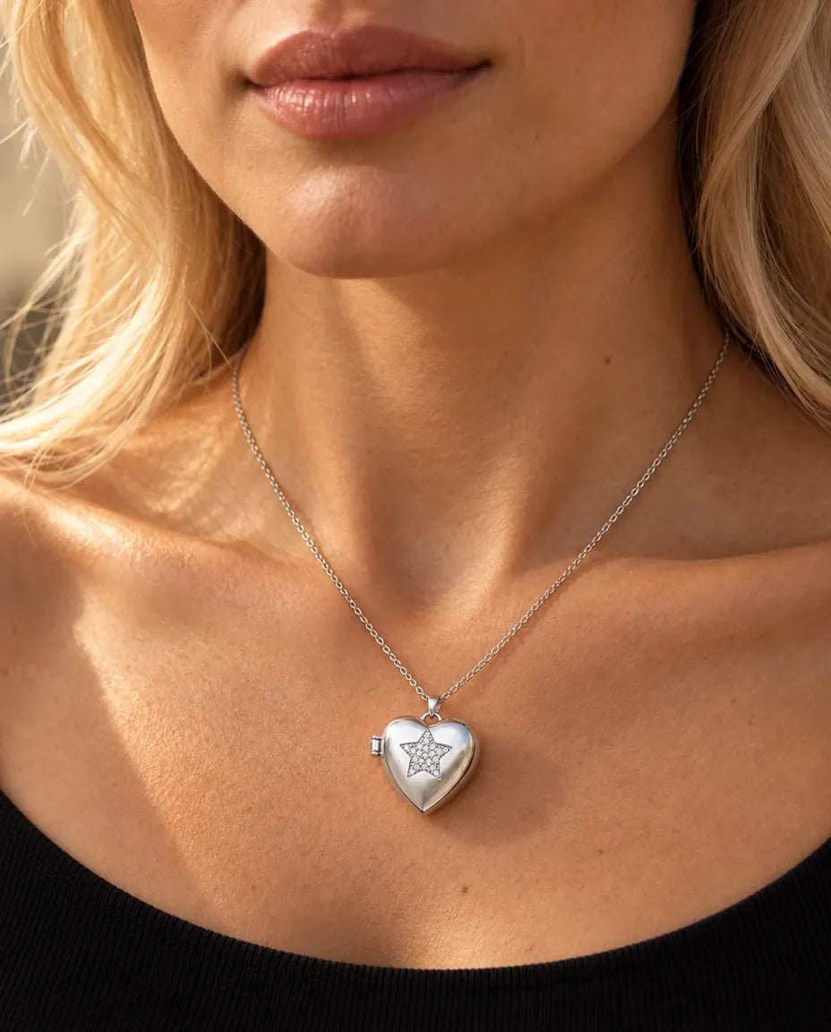 Donna con un top nero in maglia che indossa la collana portafoto a cuore con stella argentata