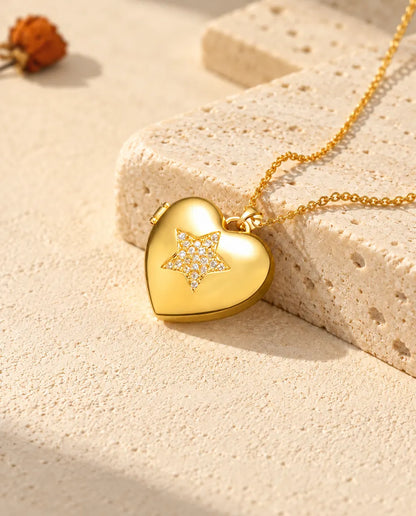 Collana portafoto a cuore con stella dorata appoggiata a un blocco di travertino