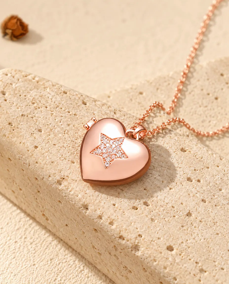 Collana portafoto a cuore con stella color oro rosa sul travertino, alla luce calda del sole