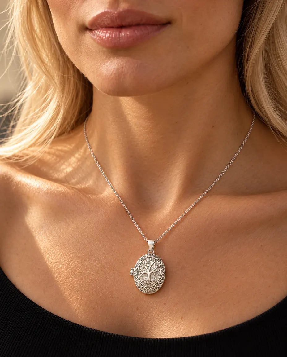 Donna con un top nero in maglia che indossa la collana portafoto argentata con l'albero della vita