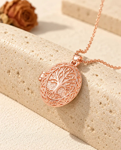 Ciondolo portafoto color oro rosa con albero della vita e intrecci celtici posato sul travertino
