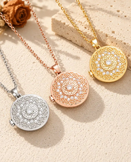 Ciondoli portafoto tondi con fiore mandala argentato, color oro rosa e dorato disposti in diagonale su gesso crema