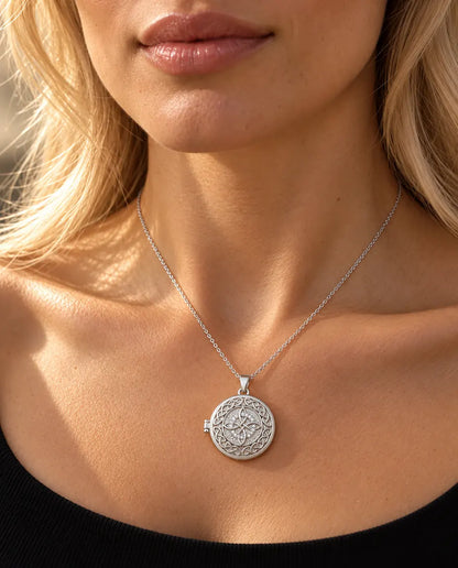 Donna con un top nero in maglia che indossa la collana portafoto argentata tonda con nodo celtico a quattro anse