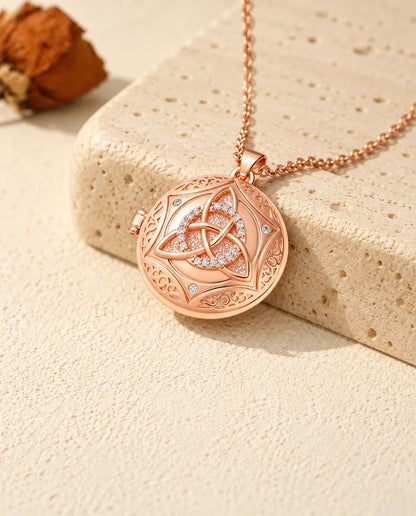 Ciondolo portafoto a nodo celtico color oro rosa con il cerchio pavé di zirconi, appoggiato sul travertino