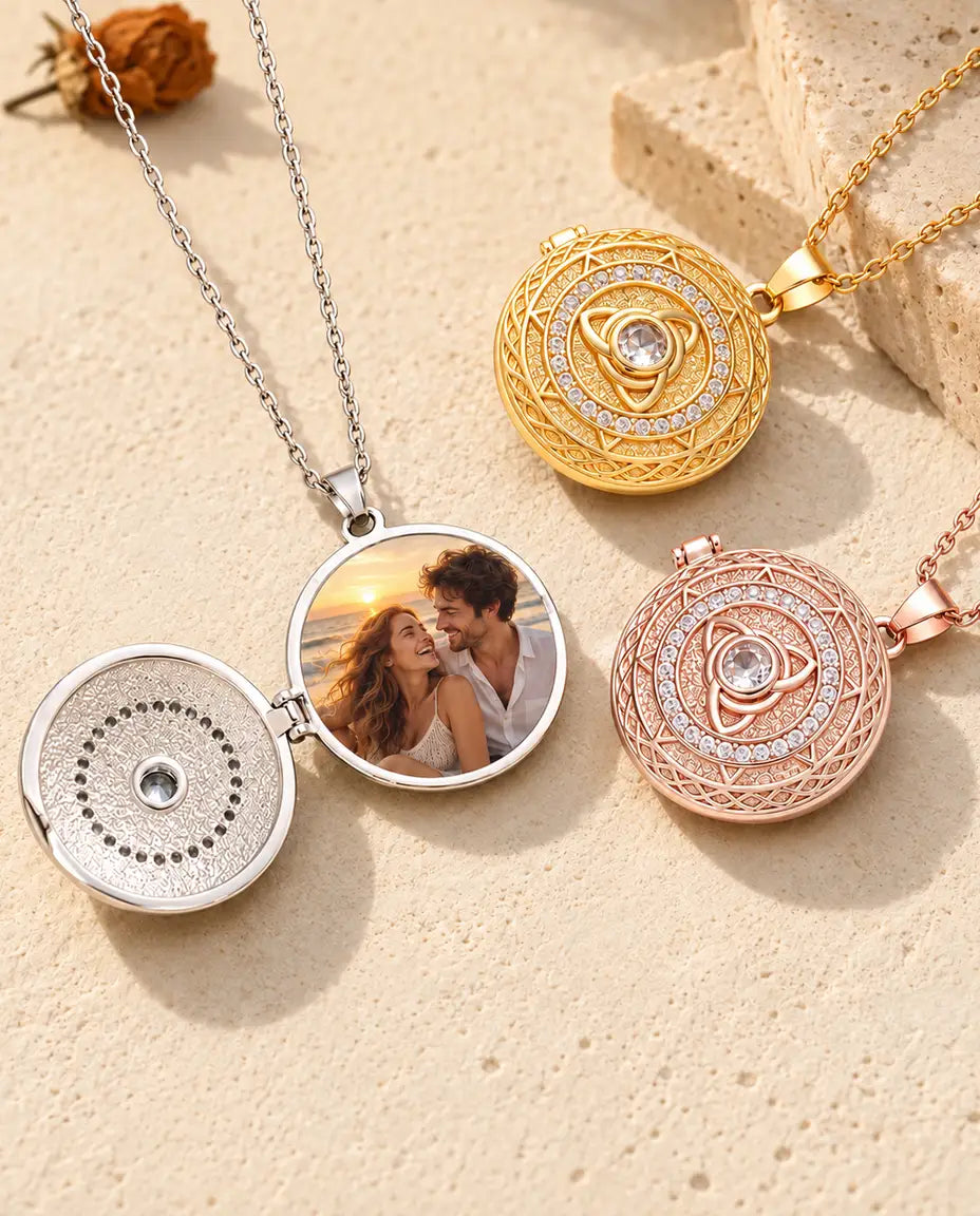 Ciondolo argentato con triquetra aperto con la foto di una coppia al mare, accanto ai modelli dorato e color oro rosa chiusi