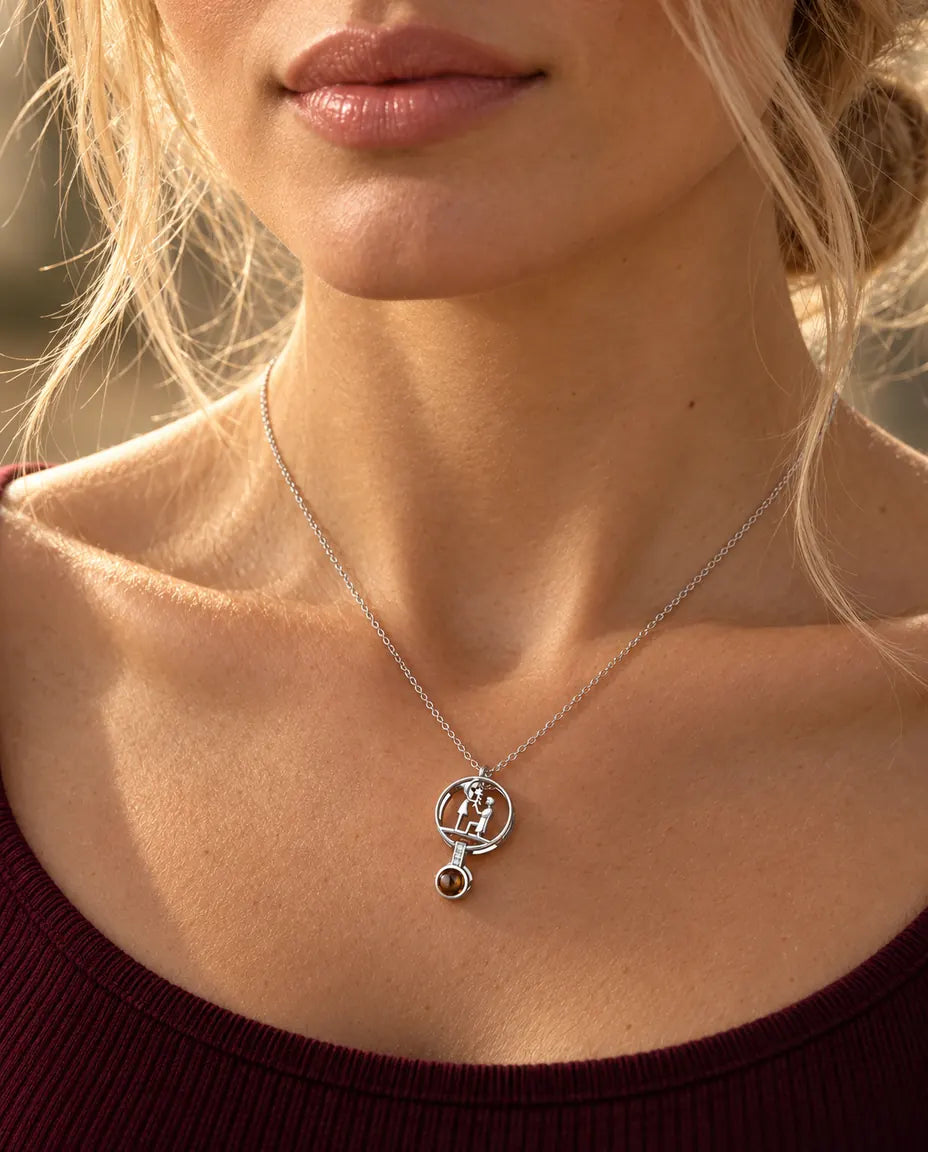 Donna con maglia bordeaux che indossa la collana argentata con la scena della proposta di matrimonio