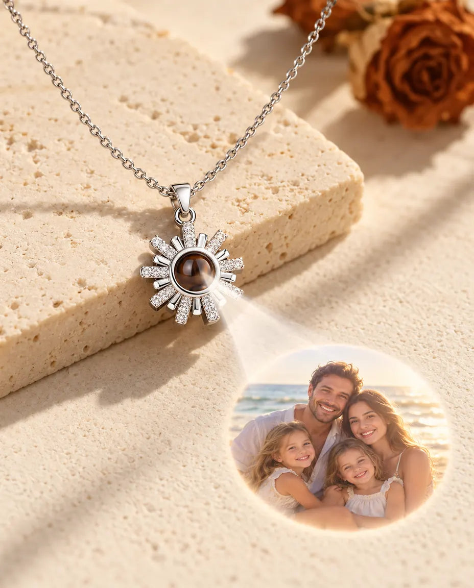 Collana argentata a sole che proietta la foto di una famiglia al mare su intonaco crema