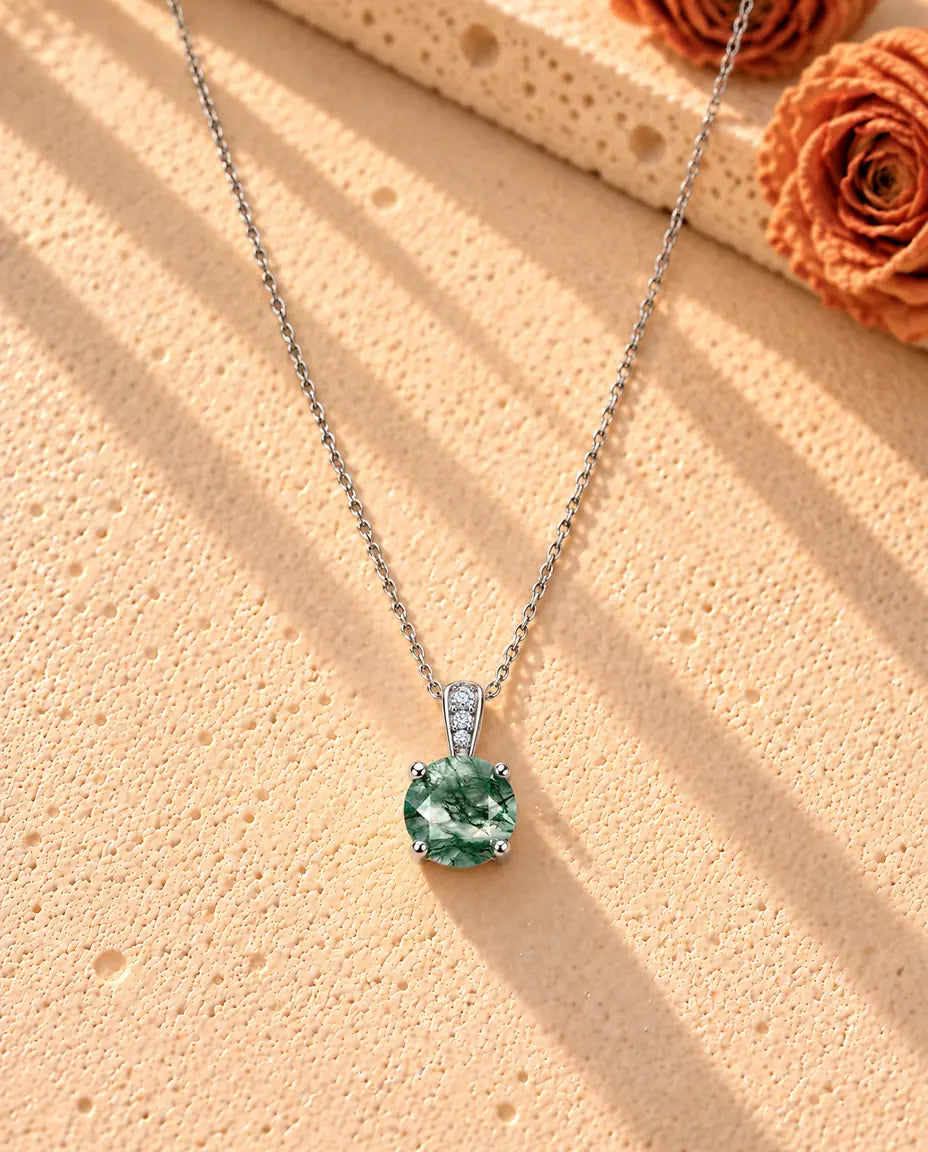Collana Solitario Agata Muschiata Tonda in Argento 925 - la collana intera distesa a lunga V su una superficie chiara ruvida