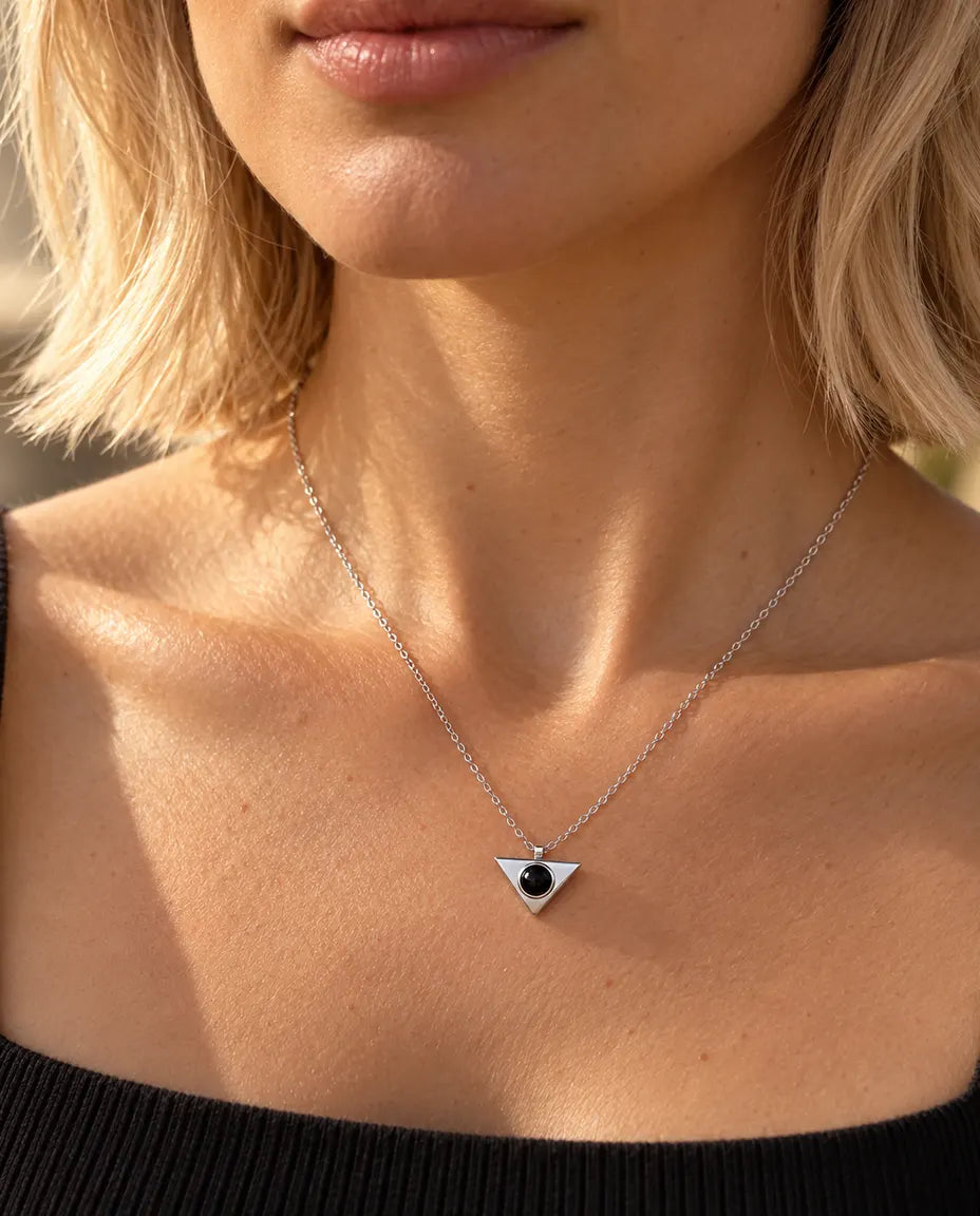 Donna con maglia nera che indossa la collana minimal argentata a triangolo con foto dentro