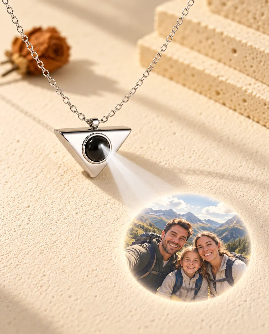 Collana argentata a triangolo che proietta la foto di una famiglia in escursione su intonaco crema