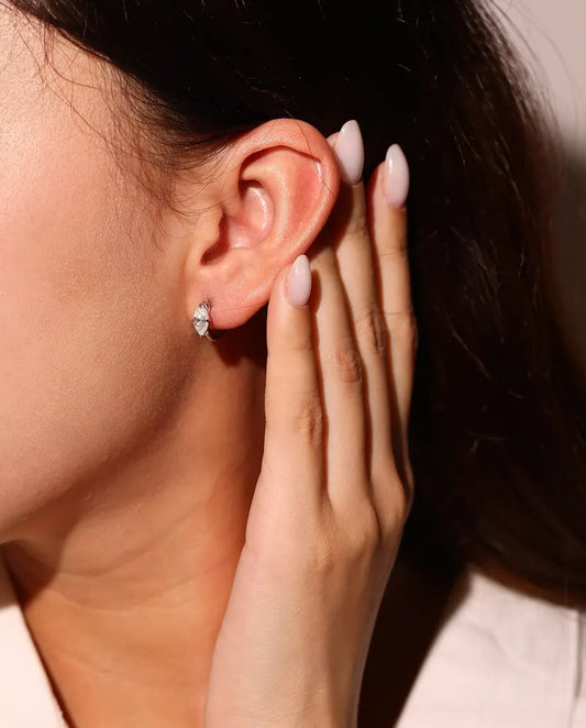 Orecchini a Cerchio Moissanite in Argento 925 - indossati all’orecchio da una modella, mano vicino al viso