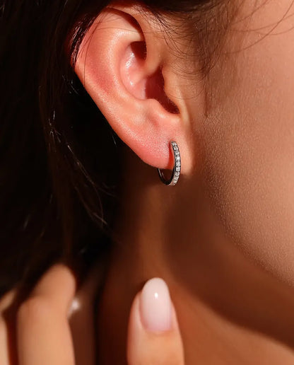 Orecchini a Cerchio Moissanite in Argento 925 - indossati all’orecchio da una modella, mano vicino al viso