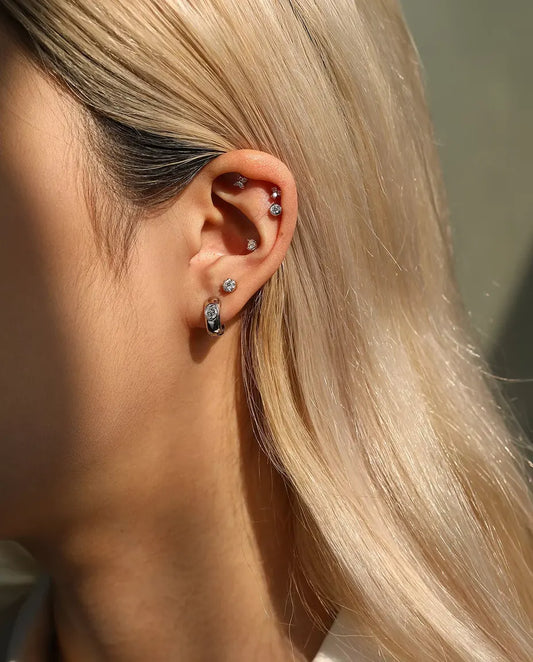 Orecchini con Moissanite Tonda e Arco Laterale in Argento 925 - indossato da una modella, inquadratura più ampia di orecchio e collo