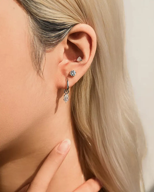 Orecchini con Moissanite Triangolare a Castone Chiuso in Argento 925 - indossato all’orecchio, primo piano